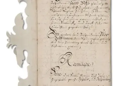 Altes handgeschriebenes Dokument mit dekorativem Rand und kalligrafischem Text auf vergilbtem Papier.